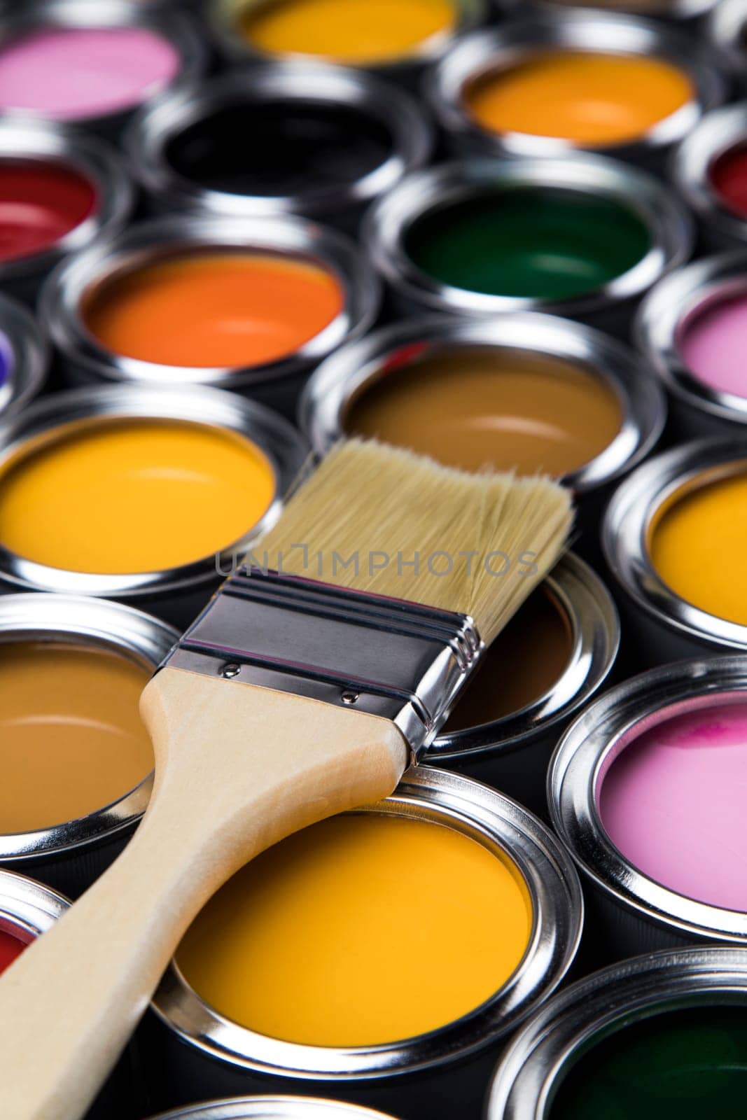 Paintbrush on cans with color