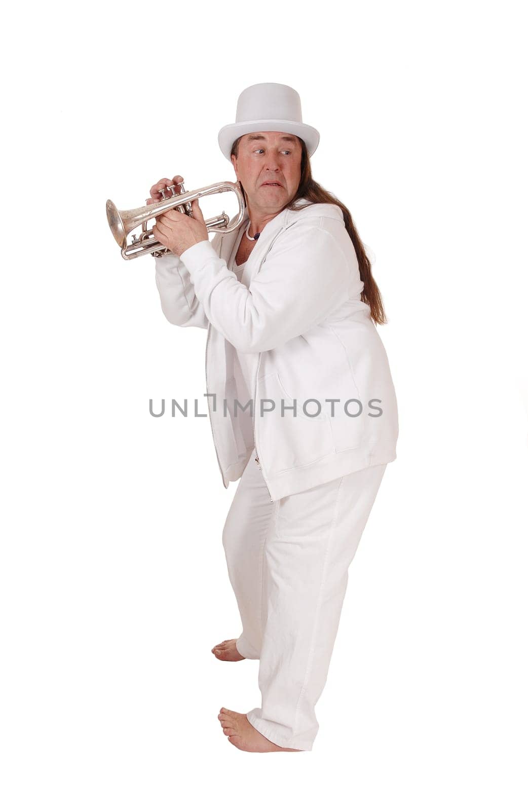 A middle age indigenous man standing in a white outfit and white hat.holding his trumpet looking back, isolated for white background.