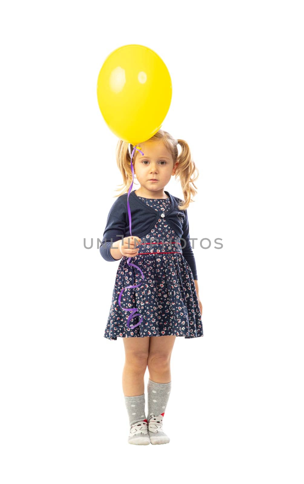 portrait of isolated blonde little girl holding yellow ballon