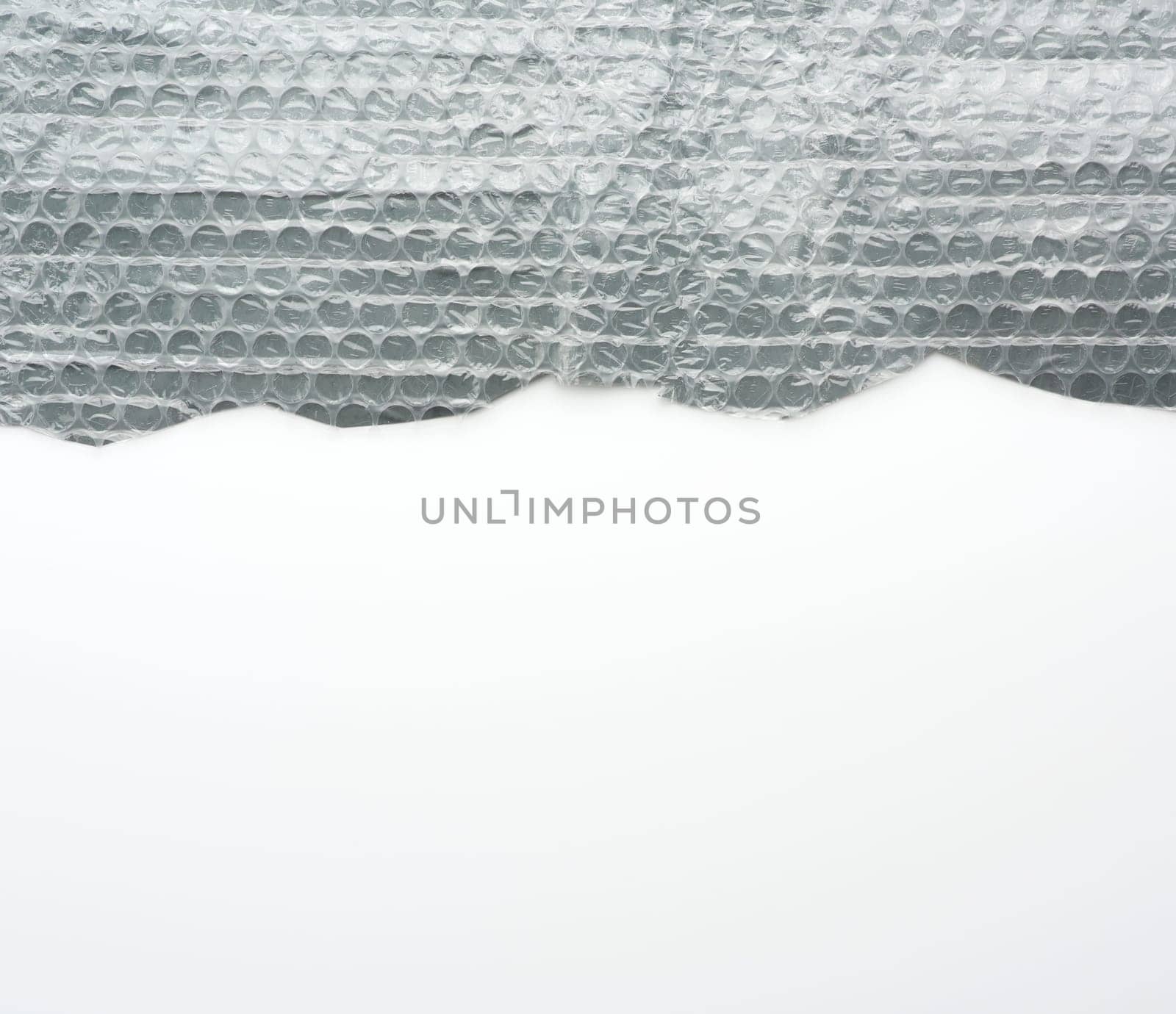 fragment of a transparent film with air for transportation of parcels is glued on gray polyethylene, inside of the envelope