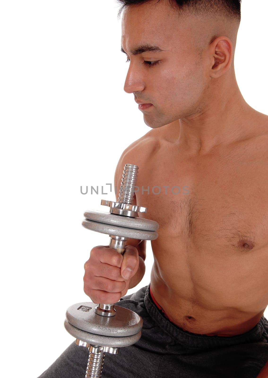 A handsome shirtless young man working out with a dumbbell with his.eyes closed, wearing his truck pants, isolated for white background.