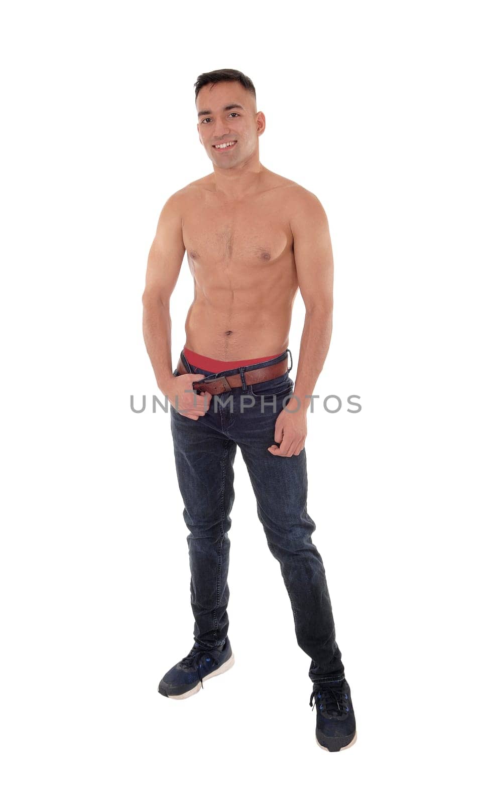 A handsome young east Indian man standing shirtless and smiling.in jeans with red underwear, isolated for white background.