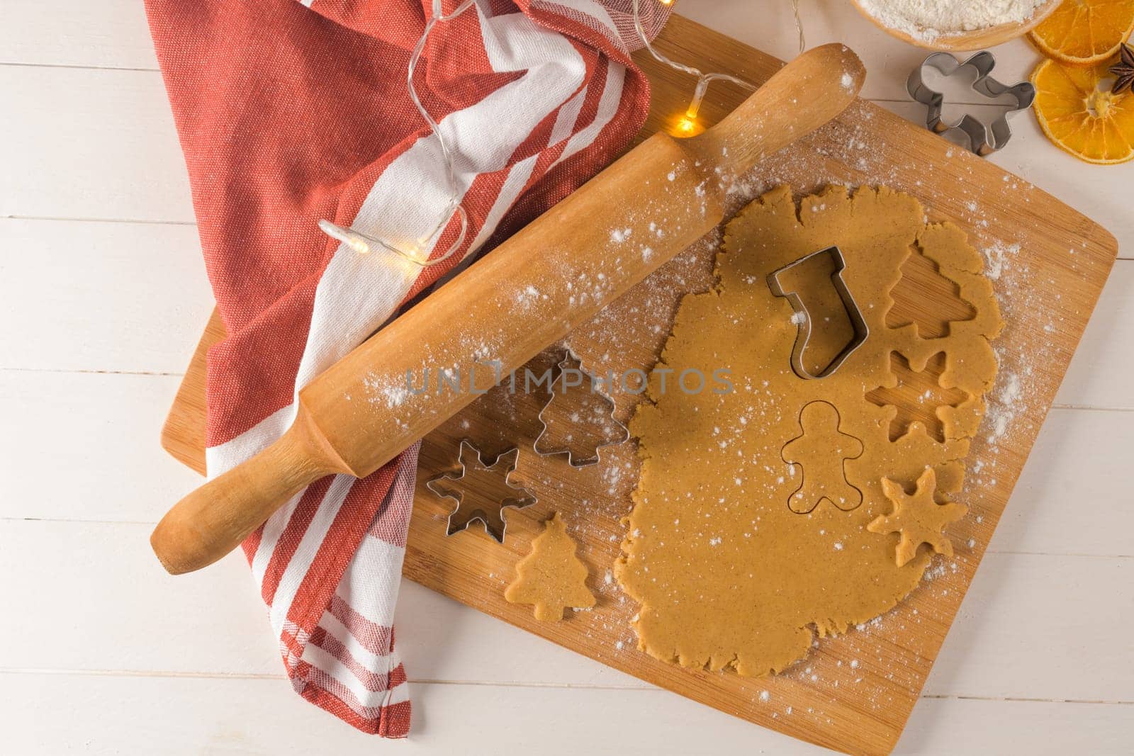 Raw dough for christmas cookies and cookie cutters on kitchen countertop.