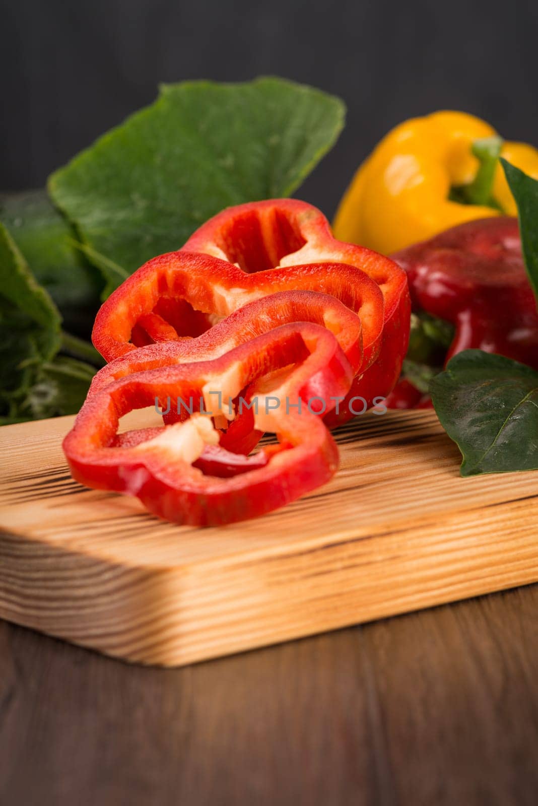 Colored bell peppers on old wooden table.