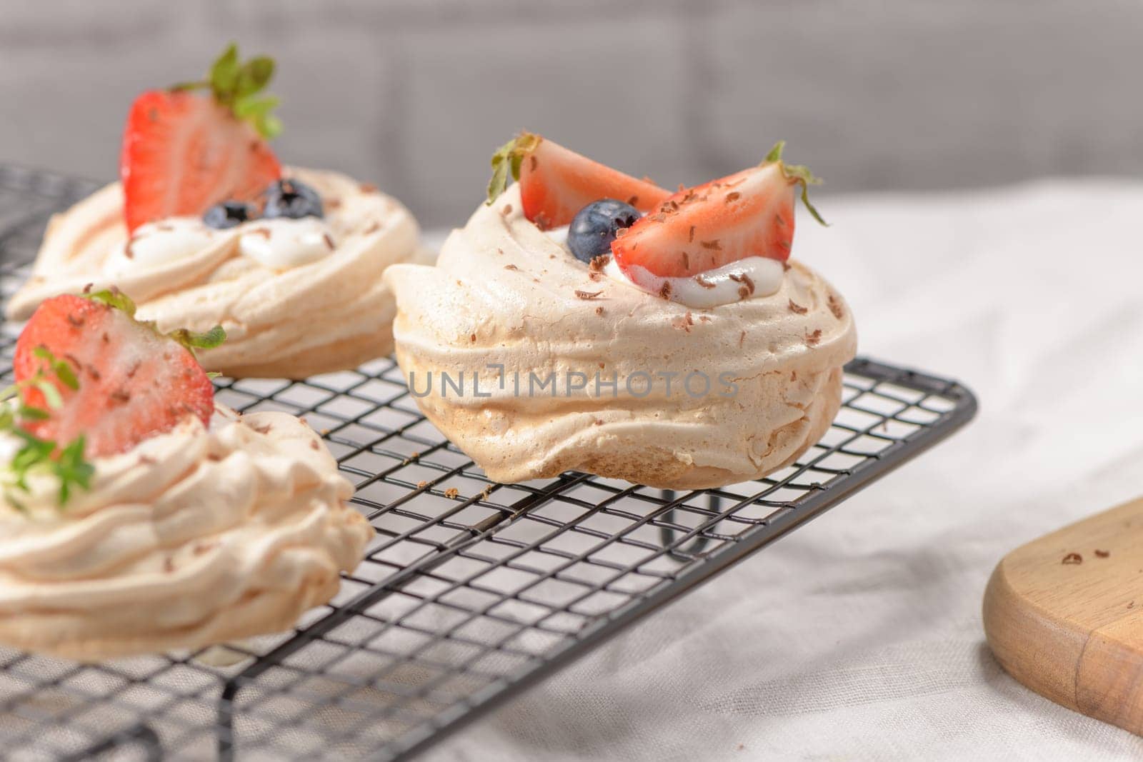 Small pavlova cakes with fresh raspberries and blueberries.