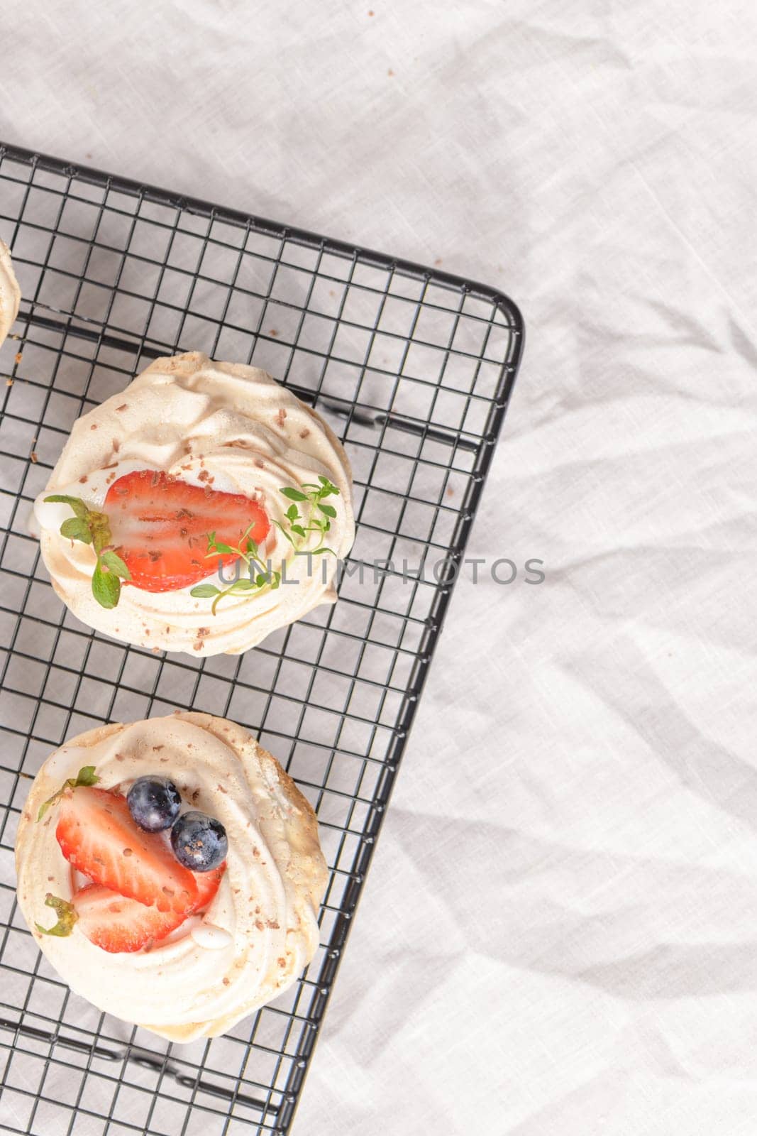 Small pavlova cakes with fresh raspberries and blueberries.