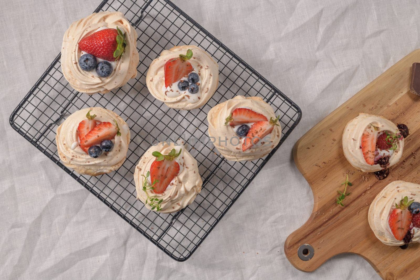 Small pavlova cakes with fresh raspberries and blueberries.