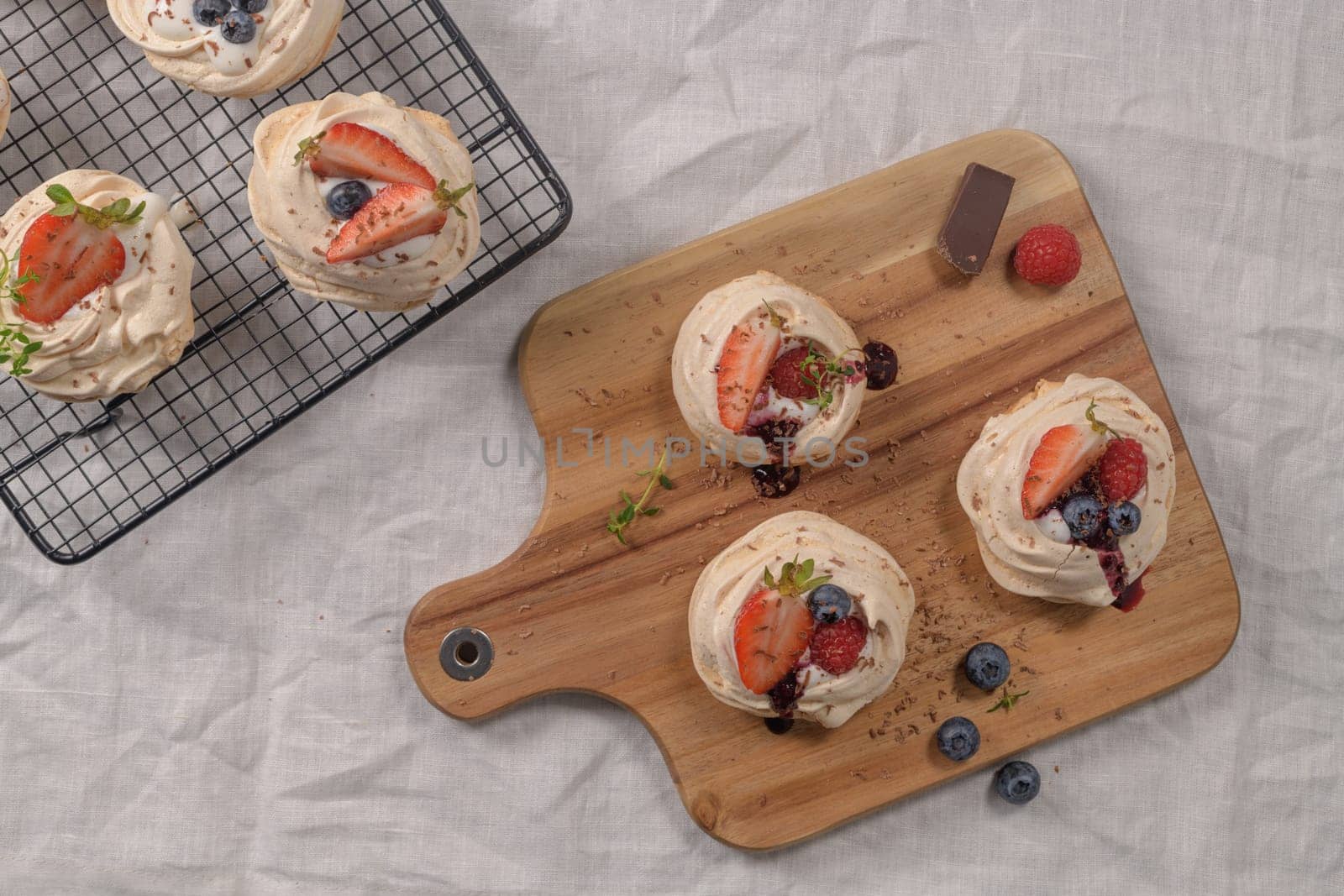 Small pavlova cakes with fresh raspberries and blueberries.