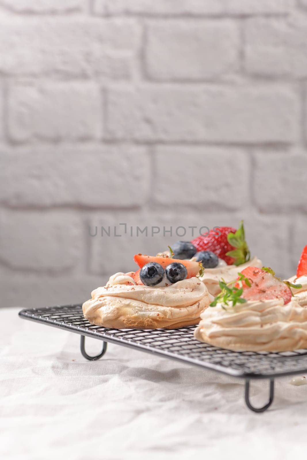 Small pavlova cakes with fresh raspberries and blueberries.