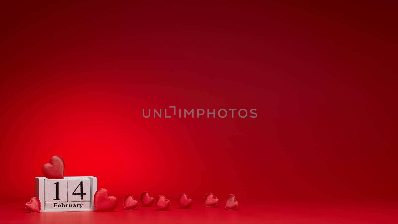 Group of silk red hearts, calendar with date 14 february on red background. Valentine's Day card with copy space. Design element for romantic greeting card, invitation. Hearts background.