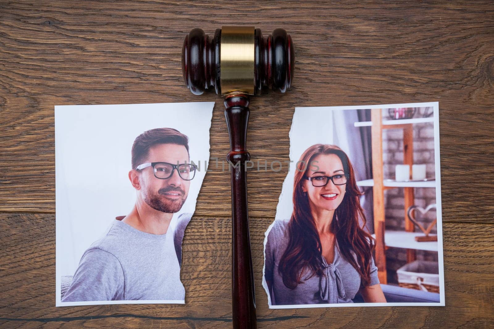 Family Photo Torn In Half Near Judge Gavel On The Wooden Desk