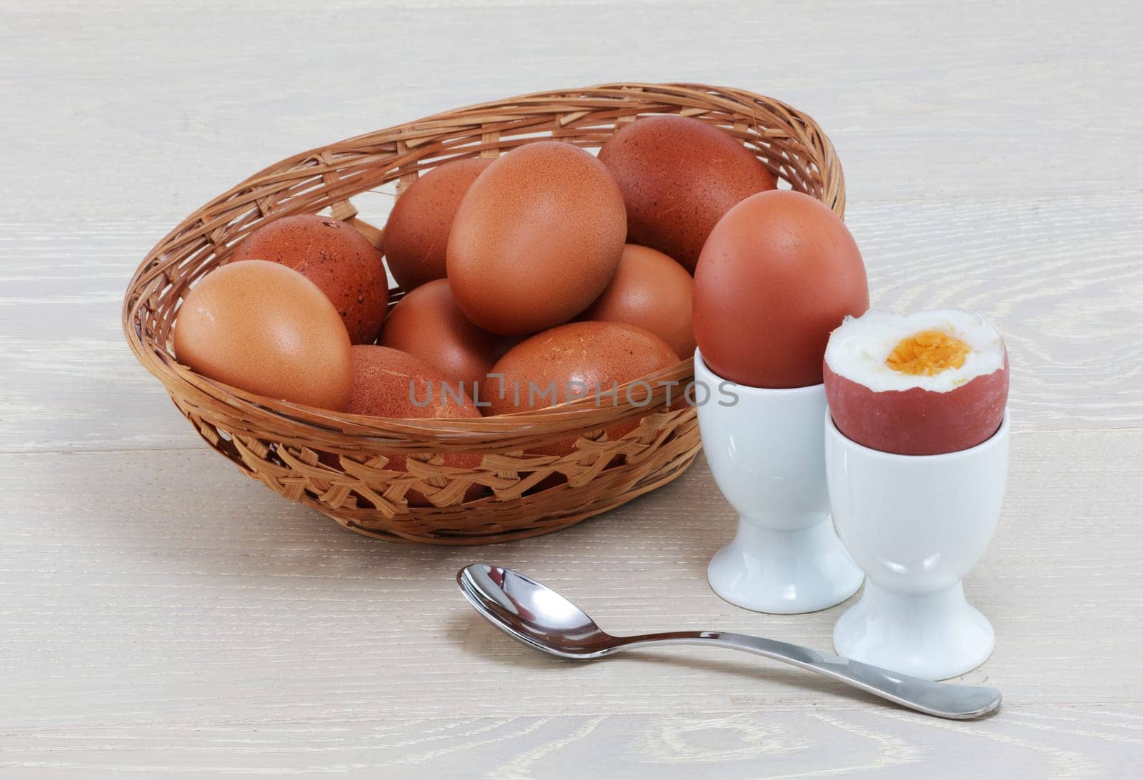 A boiled egg with basket of eggs eggcups