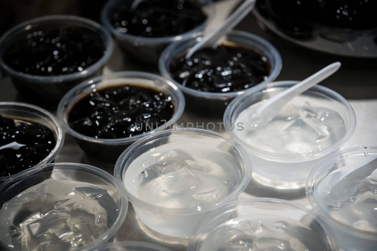Plastic transparent bowls with sweet jelly chinese dessert on a self service breakfast buffet table in a restaurant