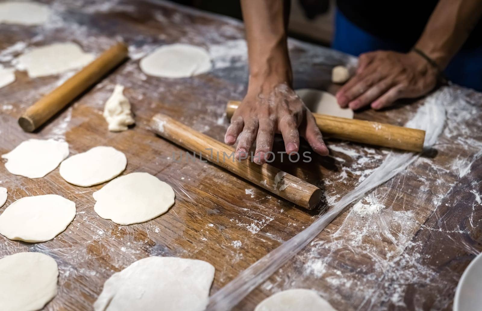 Wooden rolling pin and portioned flat dough which will be used for the making of traditional chinese dumplings during cooking class in a travellers hostel, Chengdu, Sichuan Province, China