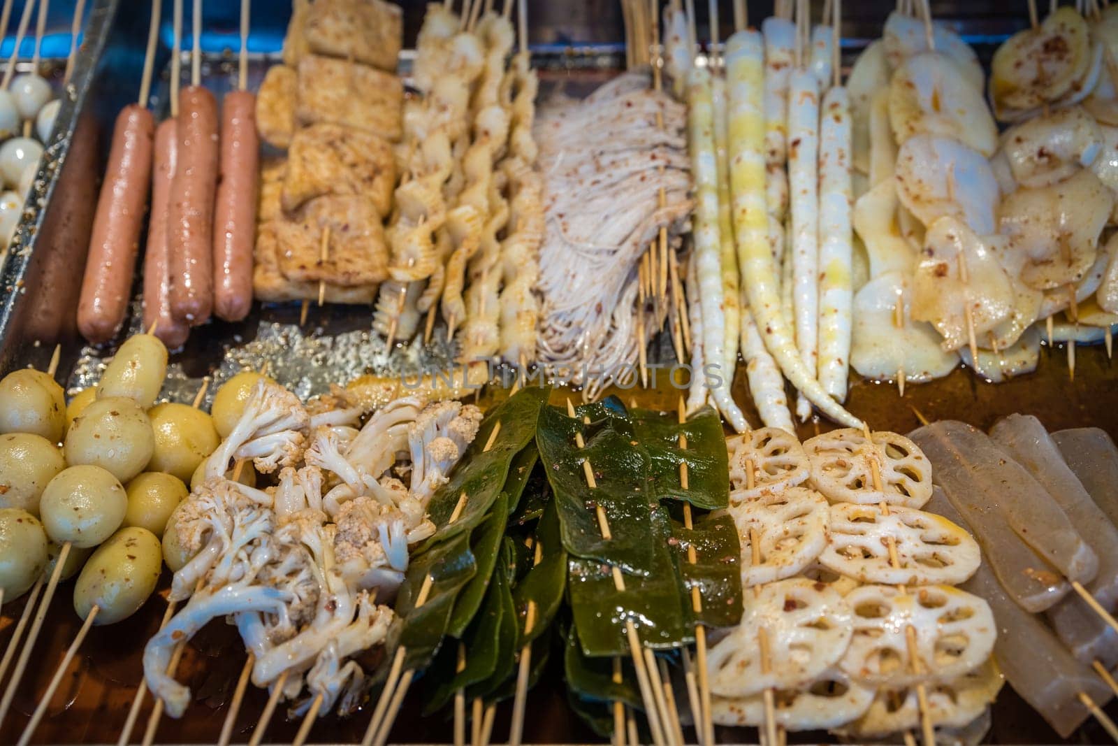 Portions of meat, sausages, potatoes, seafood and cut vegetables on wooden sticks, ready to be grilled on the street in the Muslim Quarter, Xian town, China