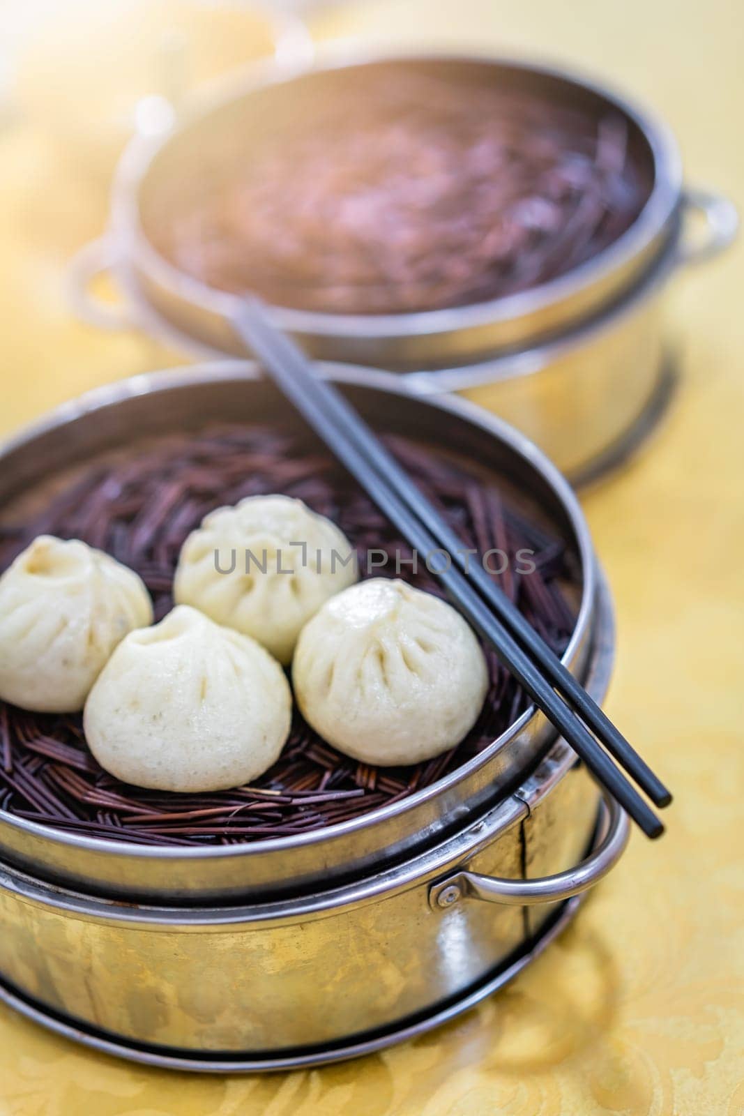 Delicious traditional chinese Baozi buns, steamed buns filled with ground pork meat and cabbage prepared on hot steam, steamed. China