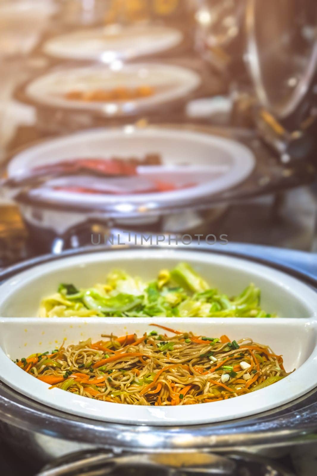 Fried noodles and boiled pakchoy in a serving bowl as a asian style breakfast buffet on the table in hotel cafeteria, China