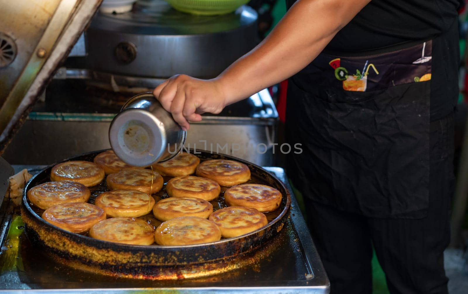 Man making bread pancakes from flour dough in a small local bakery on the street in Muslim Quarter, Xian town, China