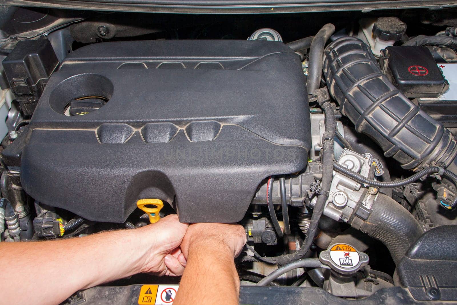 The visible hands of a mechanic. Mechanic repairs engine car. Modern diesel engine.