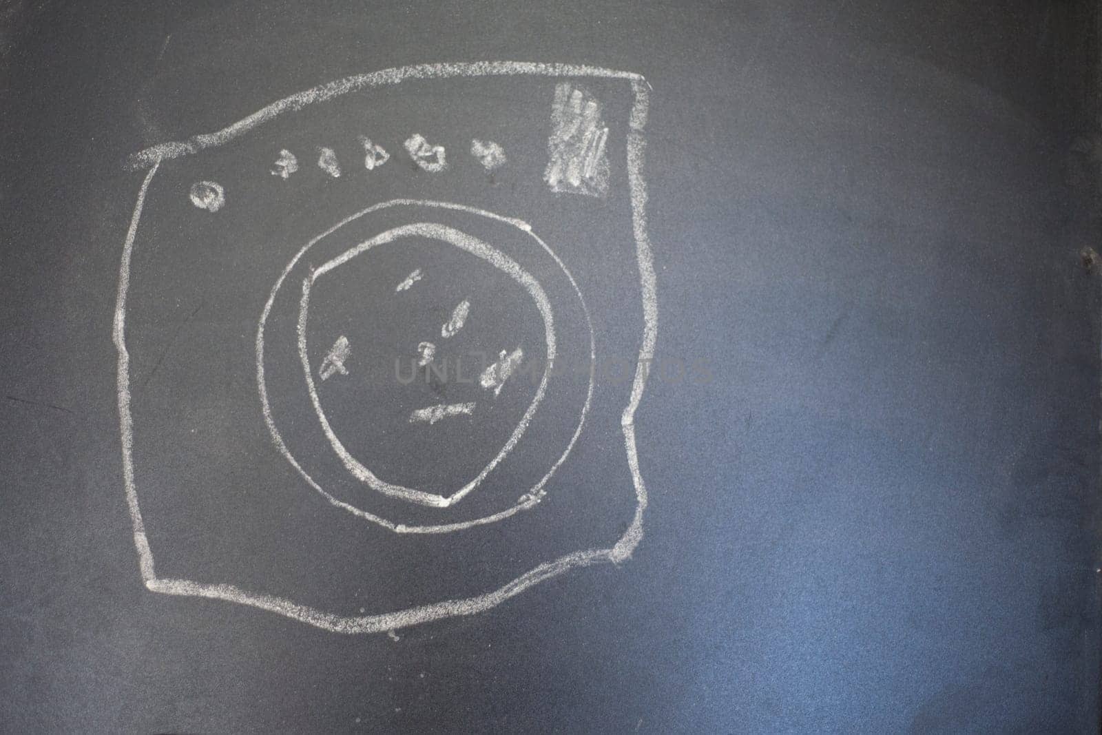 Drawing of a wash machine on a blackboard. Drawing made by child.