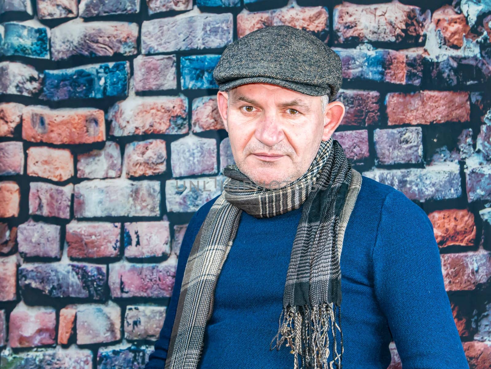 A man in a cap against a brick wall. People. Place for text. Background image. Photo model. Fashion.