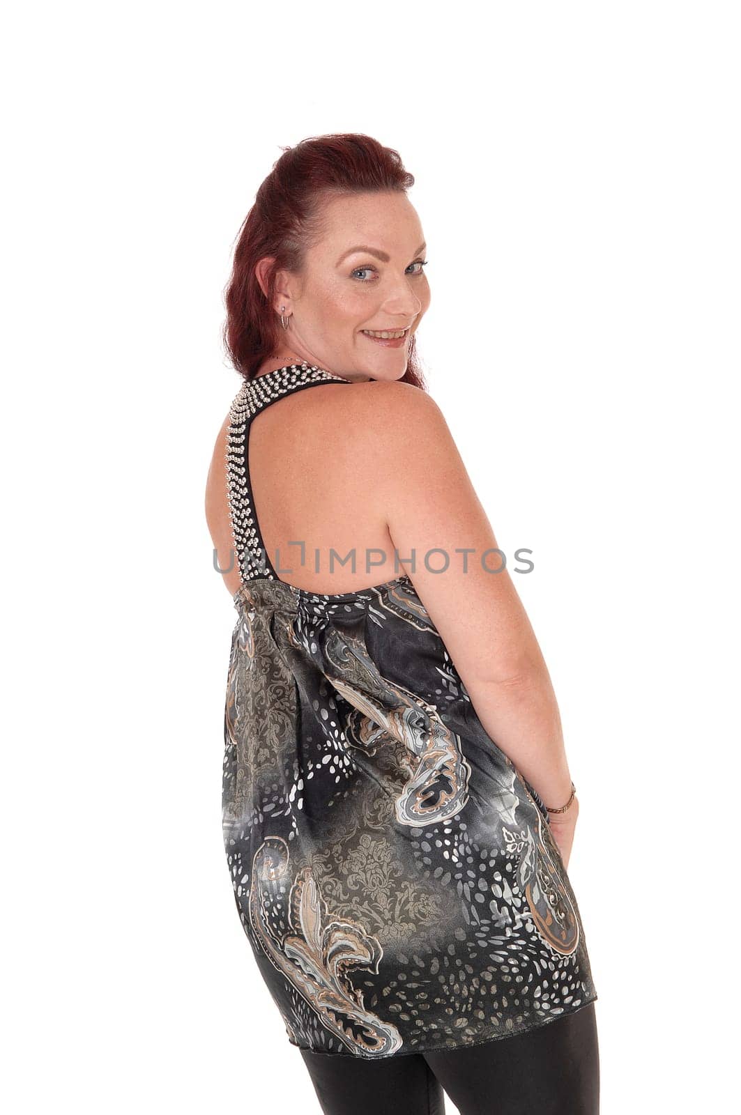 A gorgeous woman in black tights and a designer dress standing from.the back, looking over her shoulder, isolated for white background.