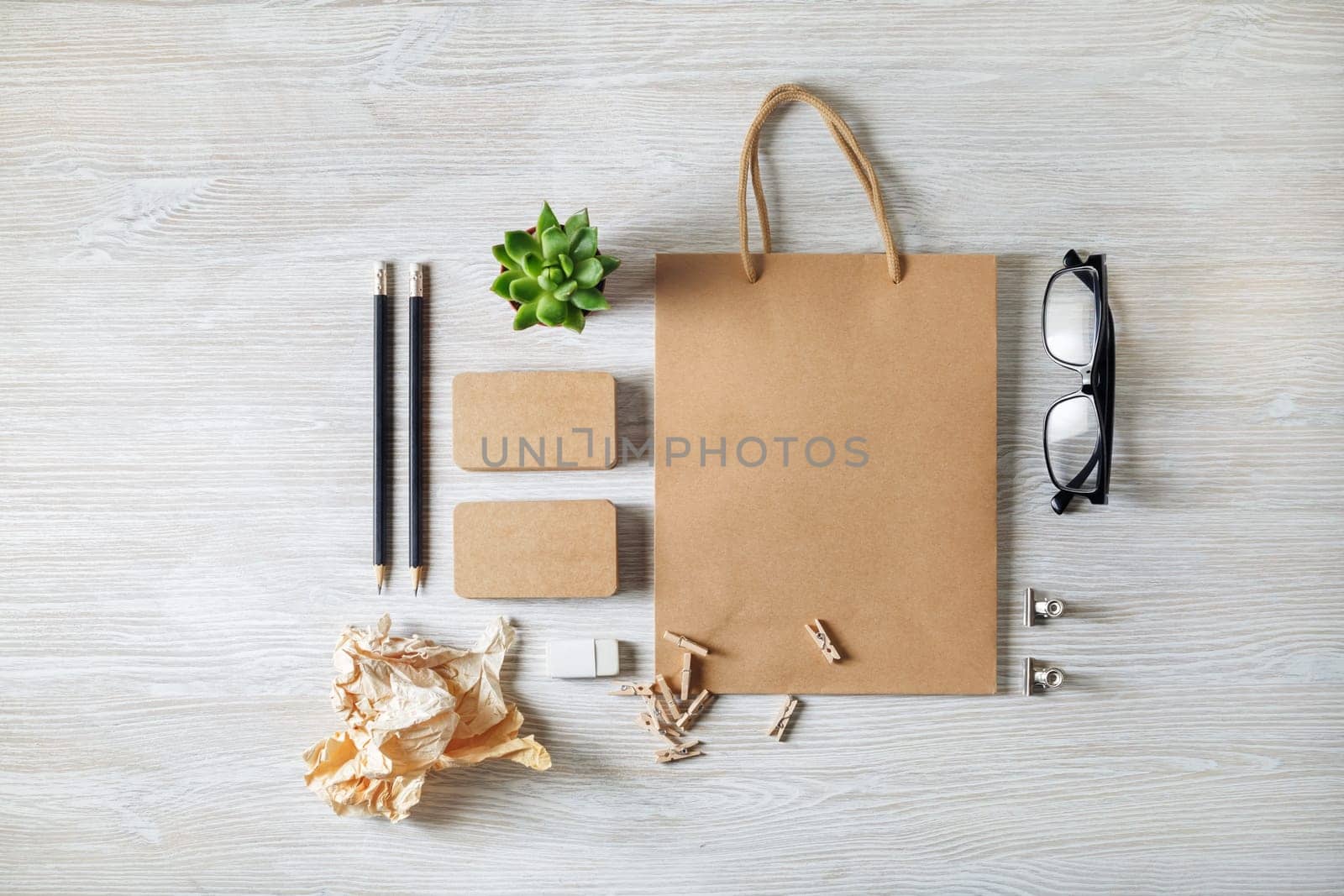Photo of blank kraft stationery set on light wooden table background. Template for branding design. Branding mock up. Flat lay.