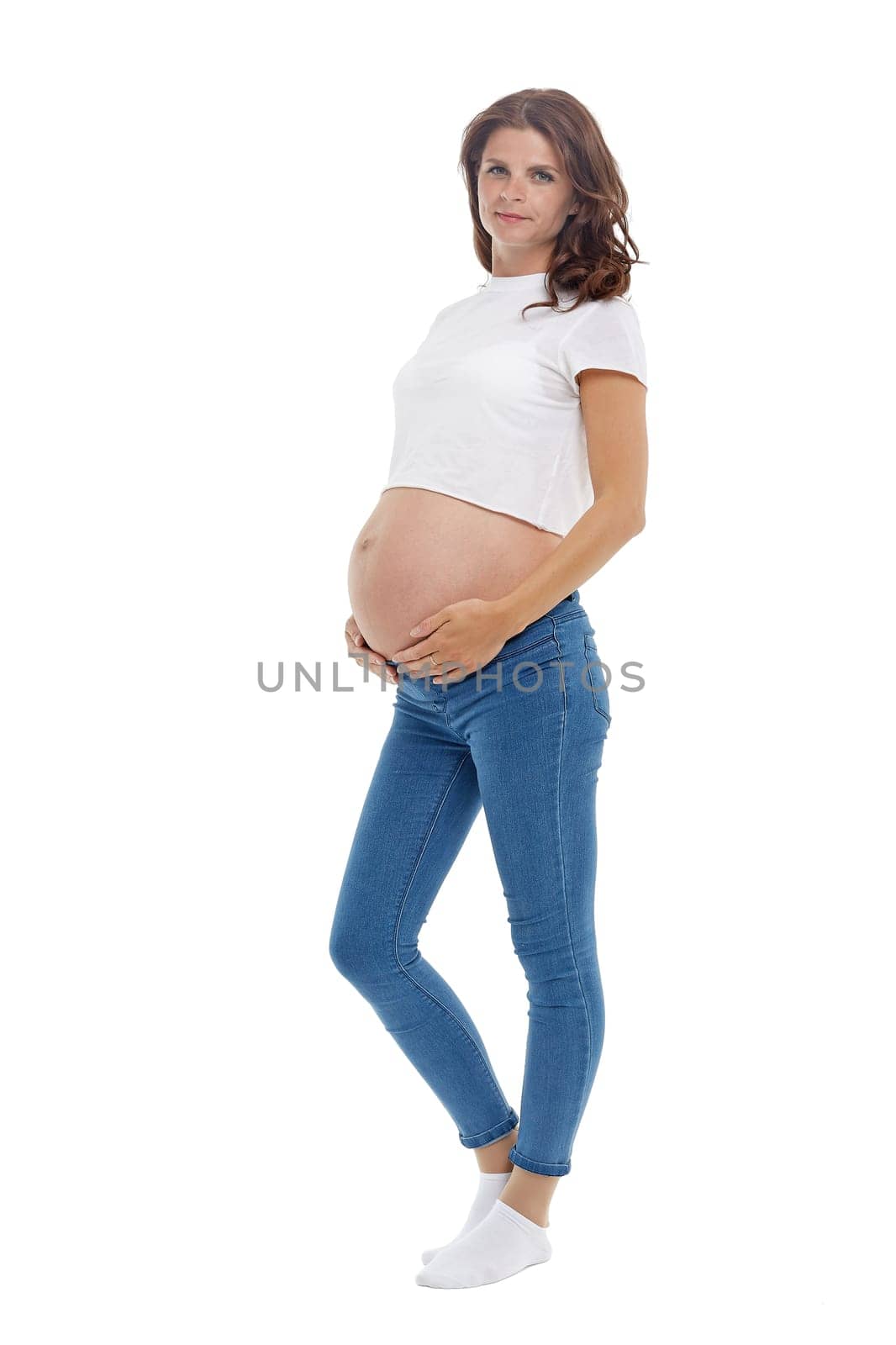Young pregnant woman is standing isolated on white background.