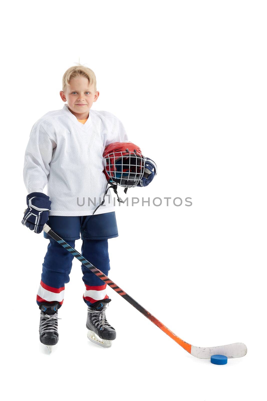 Junior ice hockey player . Child (boy) is hockey player in uniform with full equipment isolated on white background. Concept of children's sport, winter sport, healthy lifestyle.