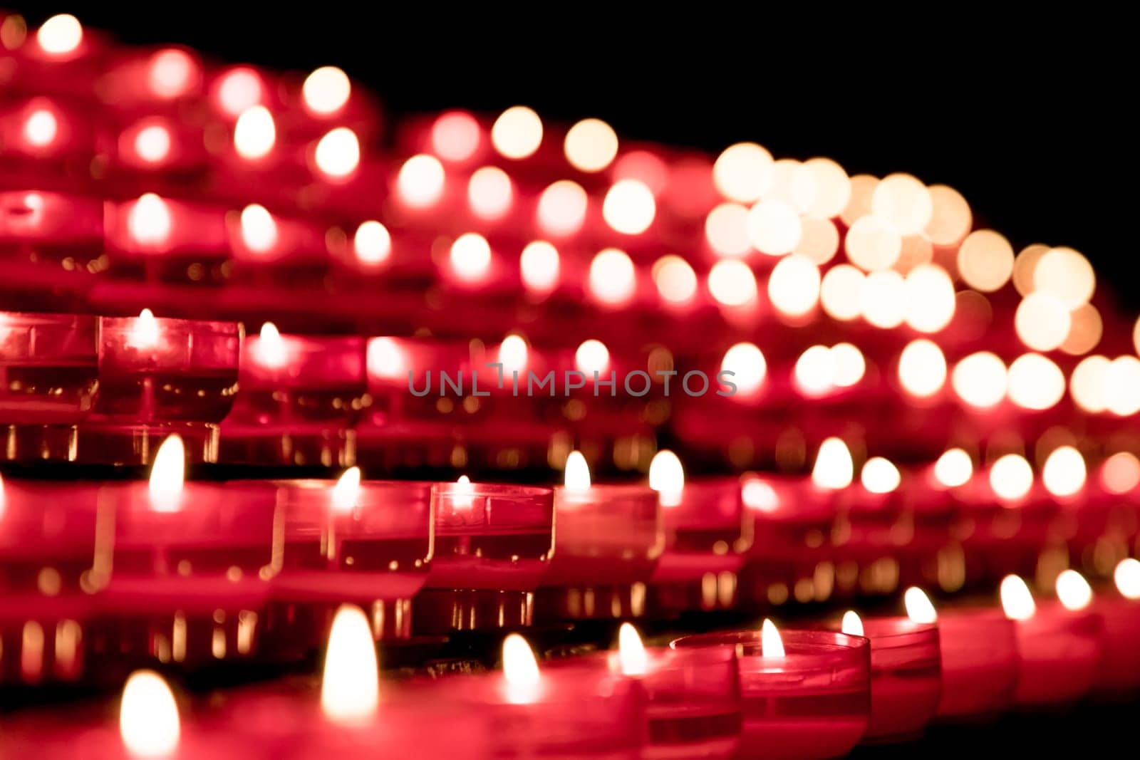 Candlelight fire flames in rows are silent religion symbol for peace, life and soul. Obituary hope sacrifice against sorrows and pain.
