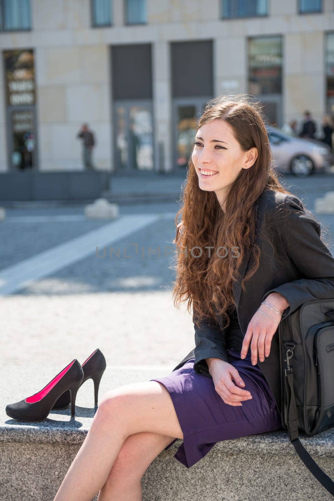 Young smiling business woman relaxing from work in city environment