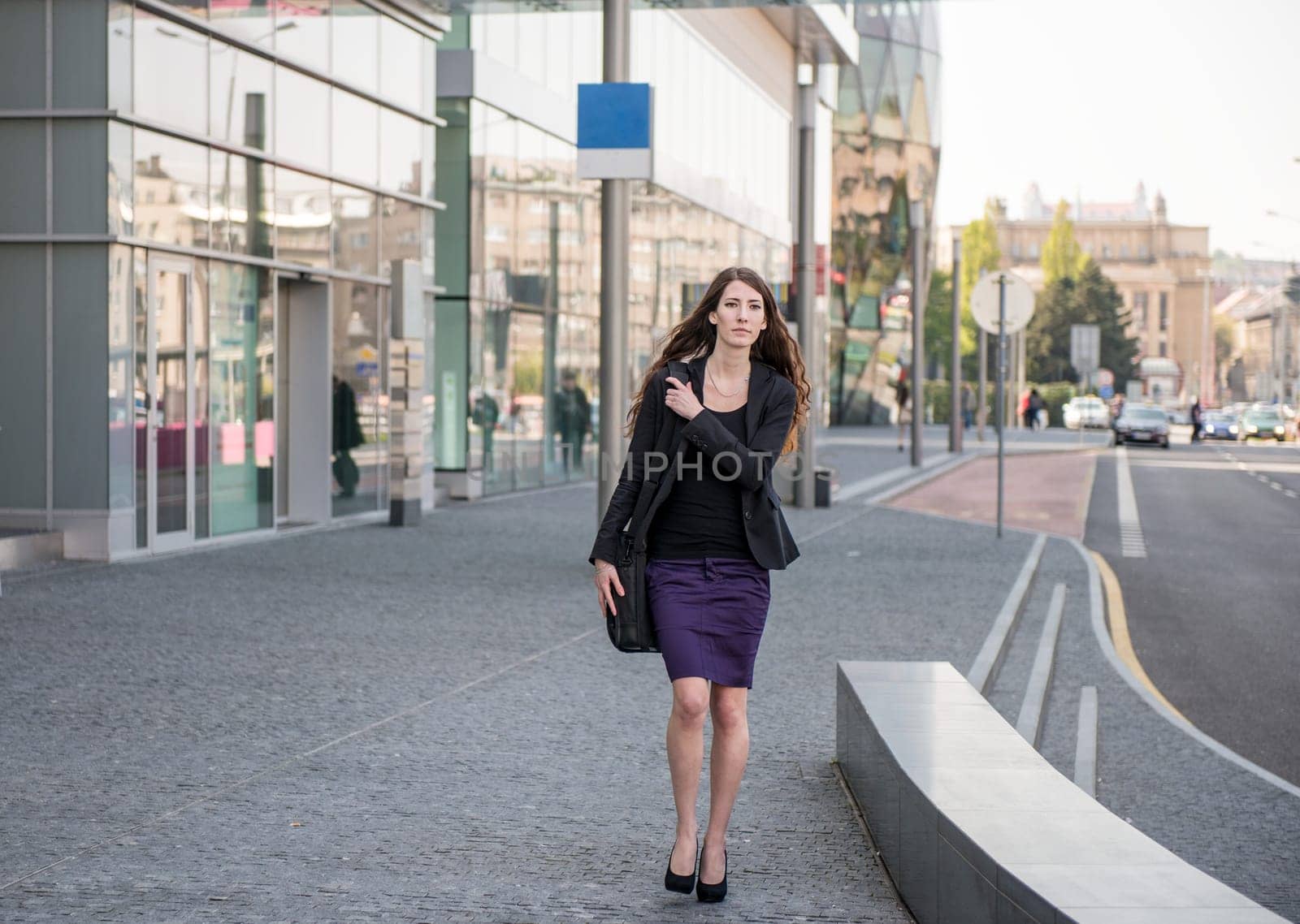 Young business woman in hurry - walking street with notebook bag