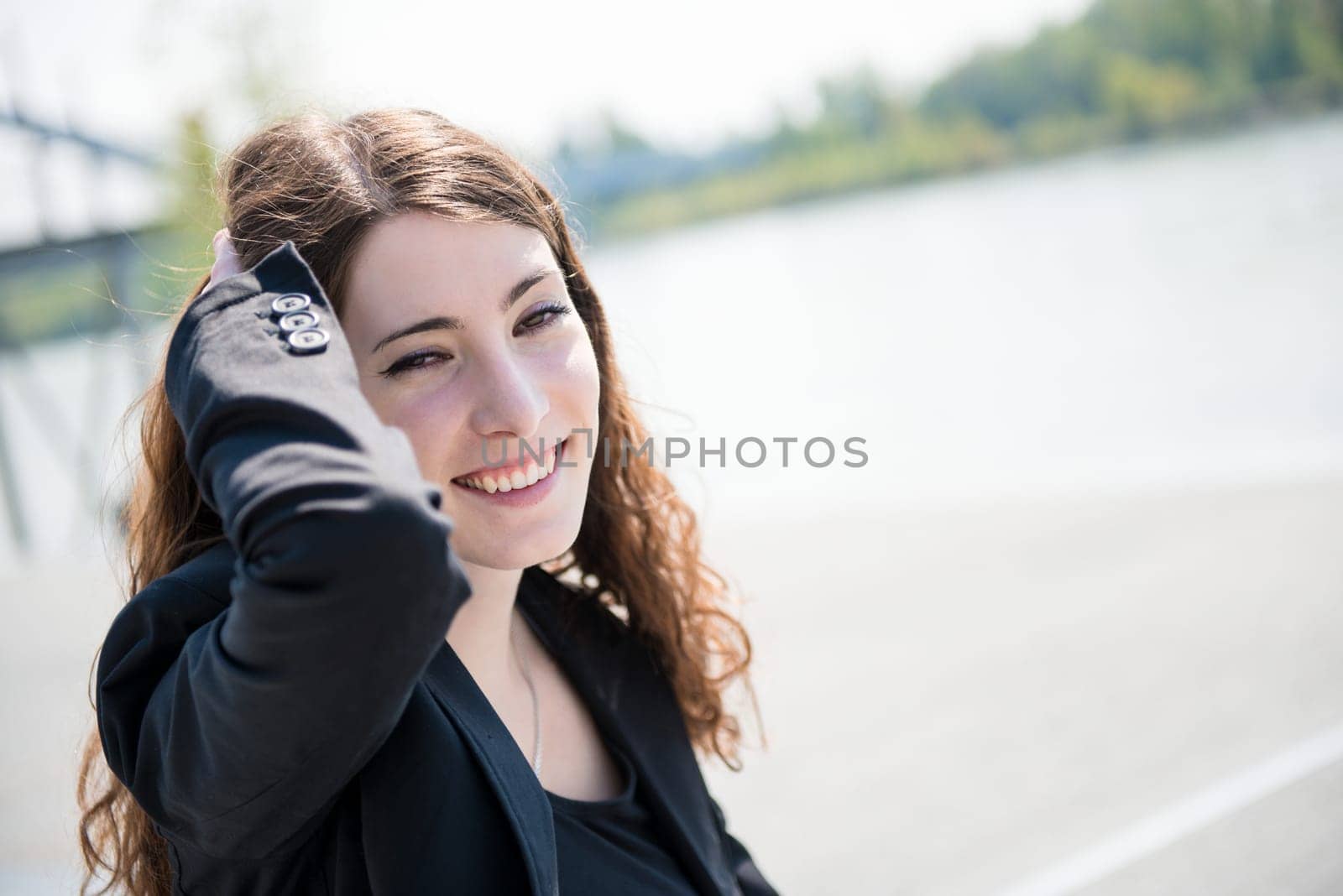 Young smiling happy woman - natural outdoor portrait, hand in hair