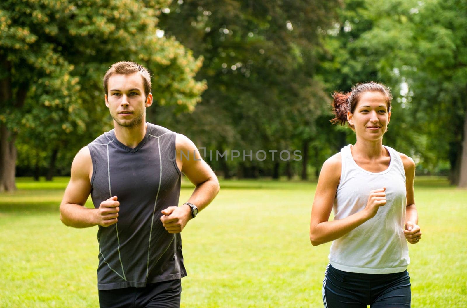 Fitness couple - young man and woman jogging outdoor in nature