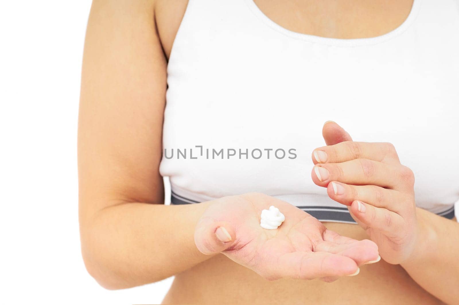 Woman in underwear applies cream on dry hands