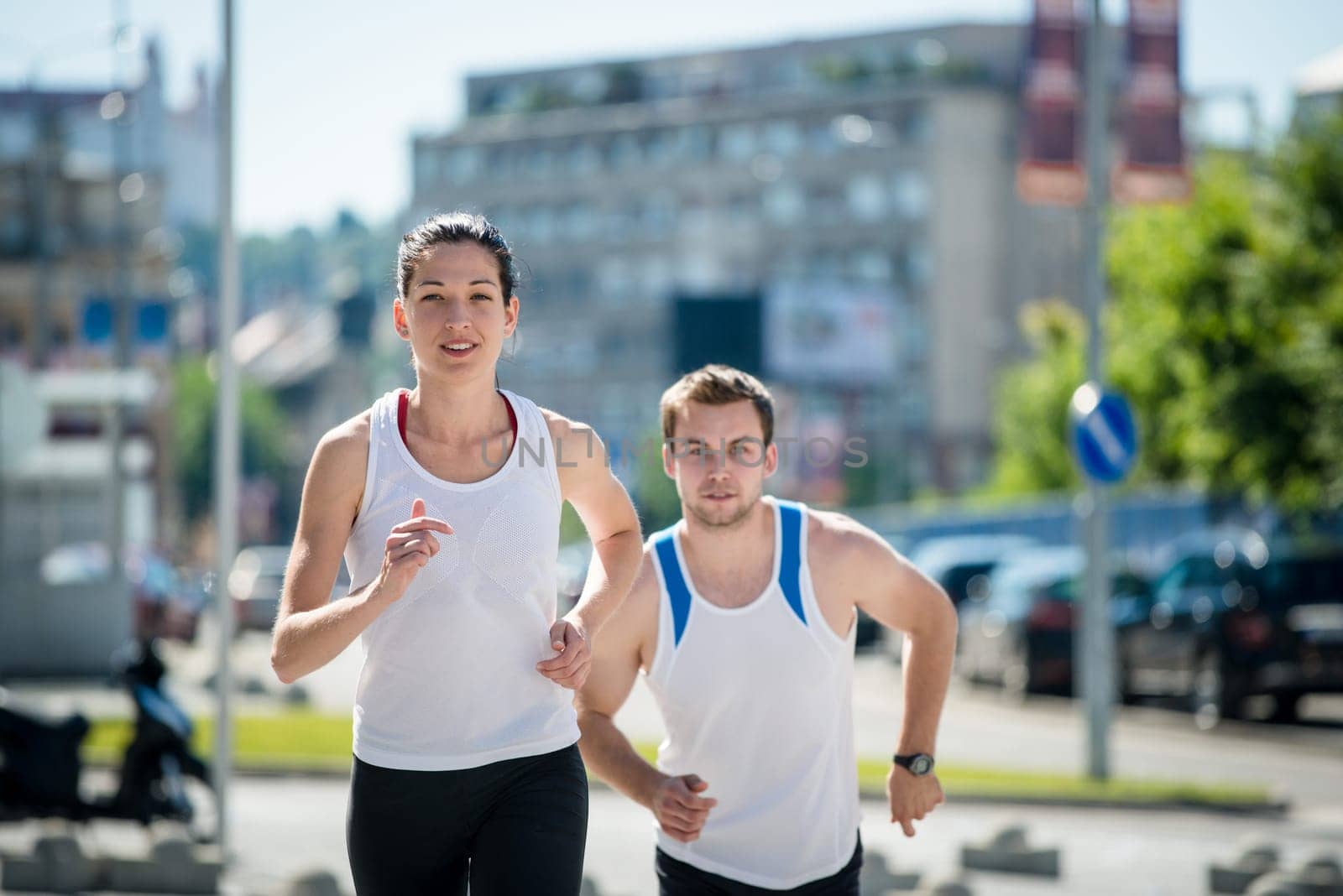Young sport couple running together in city environment