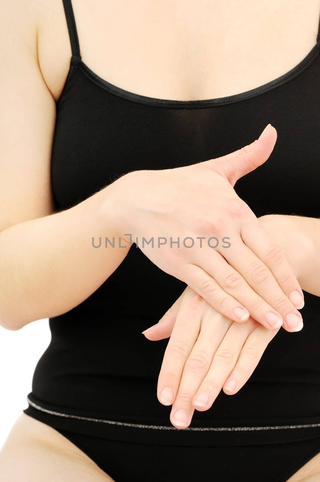 Woman in underwear applies cream on dry hands