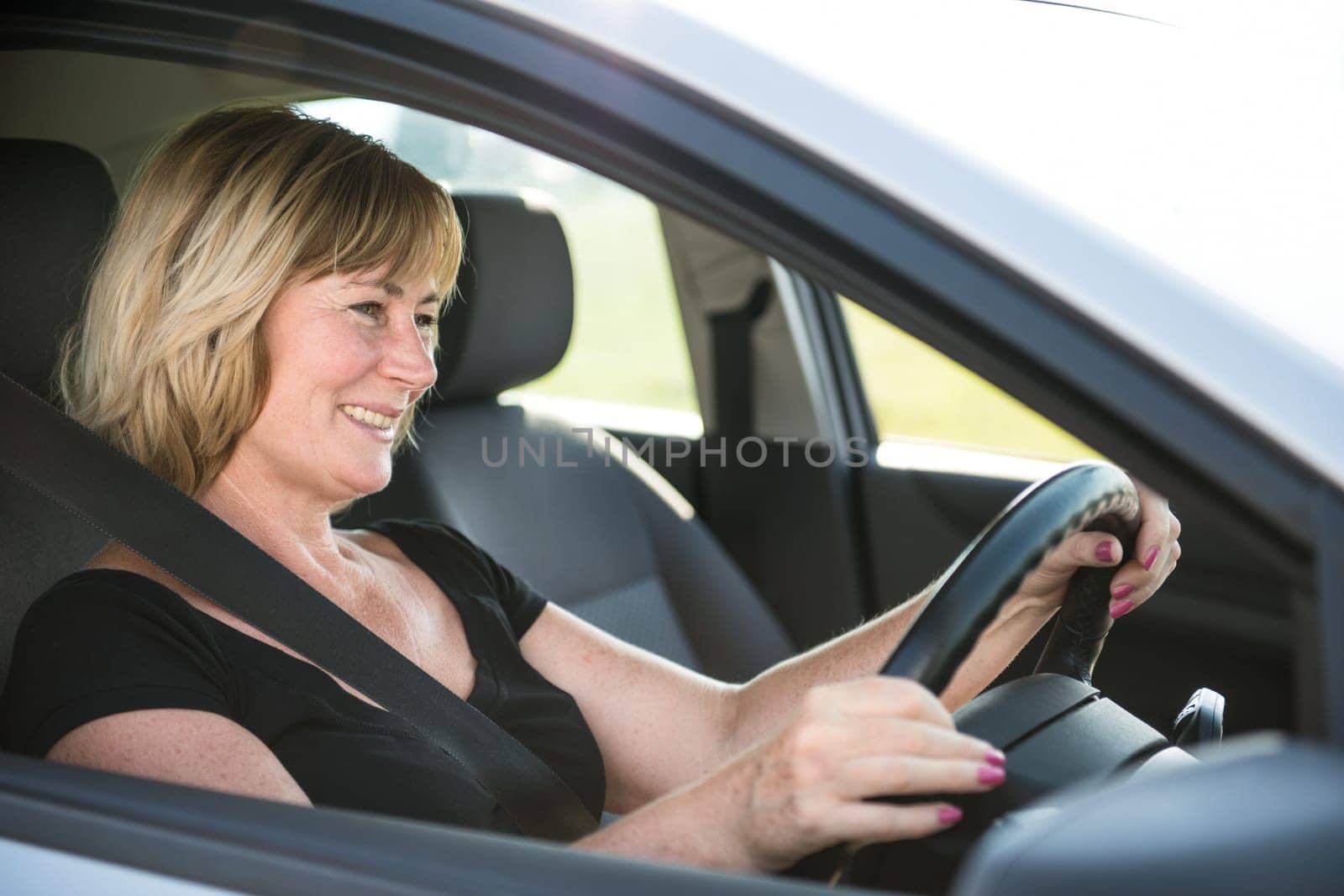 Lifestyle photo of attractive senior woman driving car