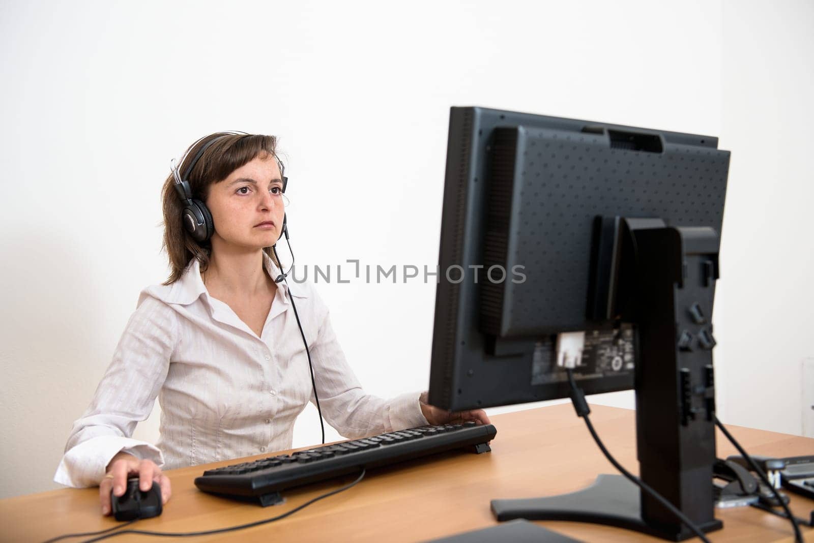 Business person (young woman) works at table with computer