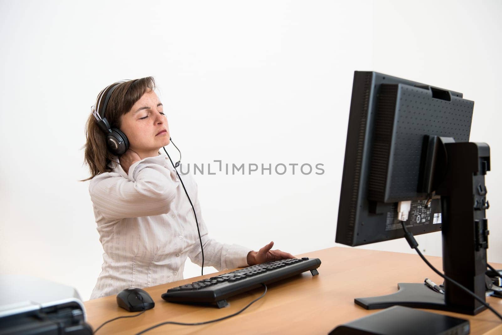 Young business person with neck pain working at computer
