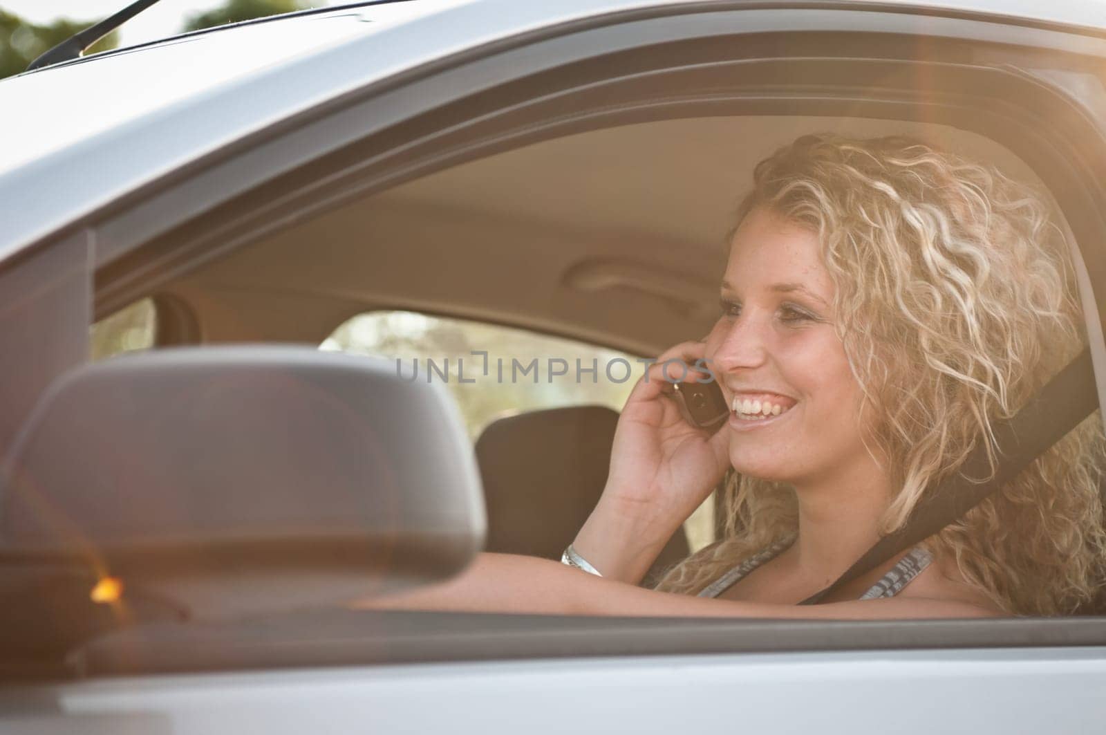 Portrait of young smiling woman driving car