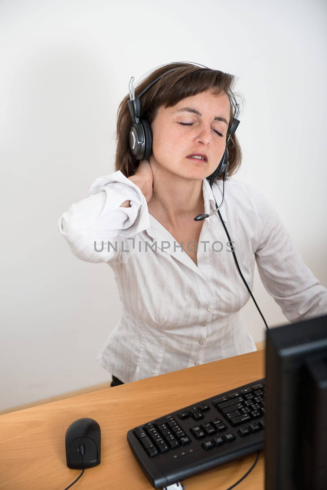 Young business person with neck pain working at computer