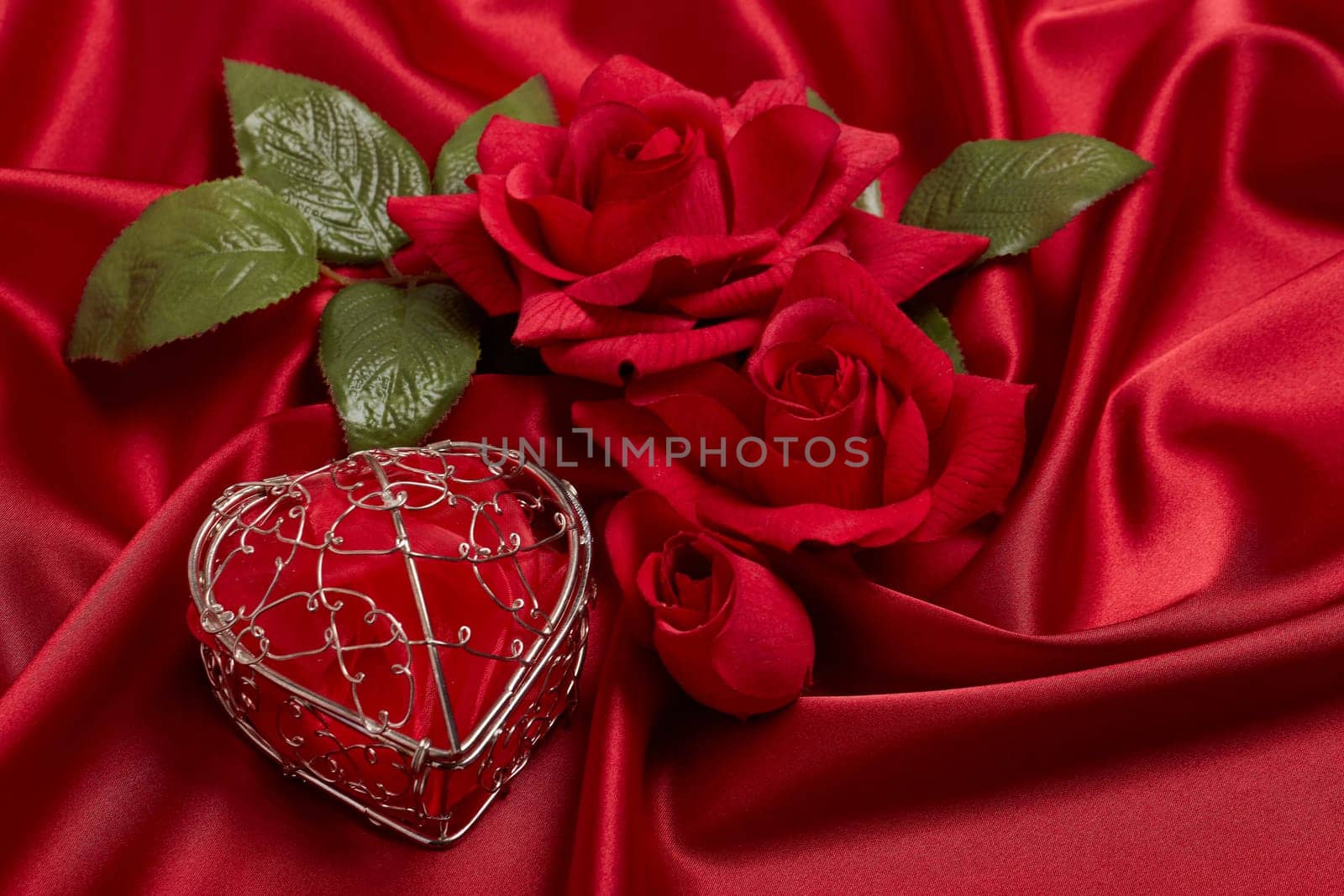 Abstract background from red silk (satin), roses and heart. Fabric texture with draped. Top view. Element design. Valentine's day. Wedding day.  Women' s day. Greeting card