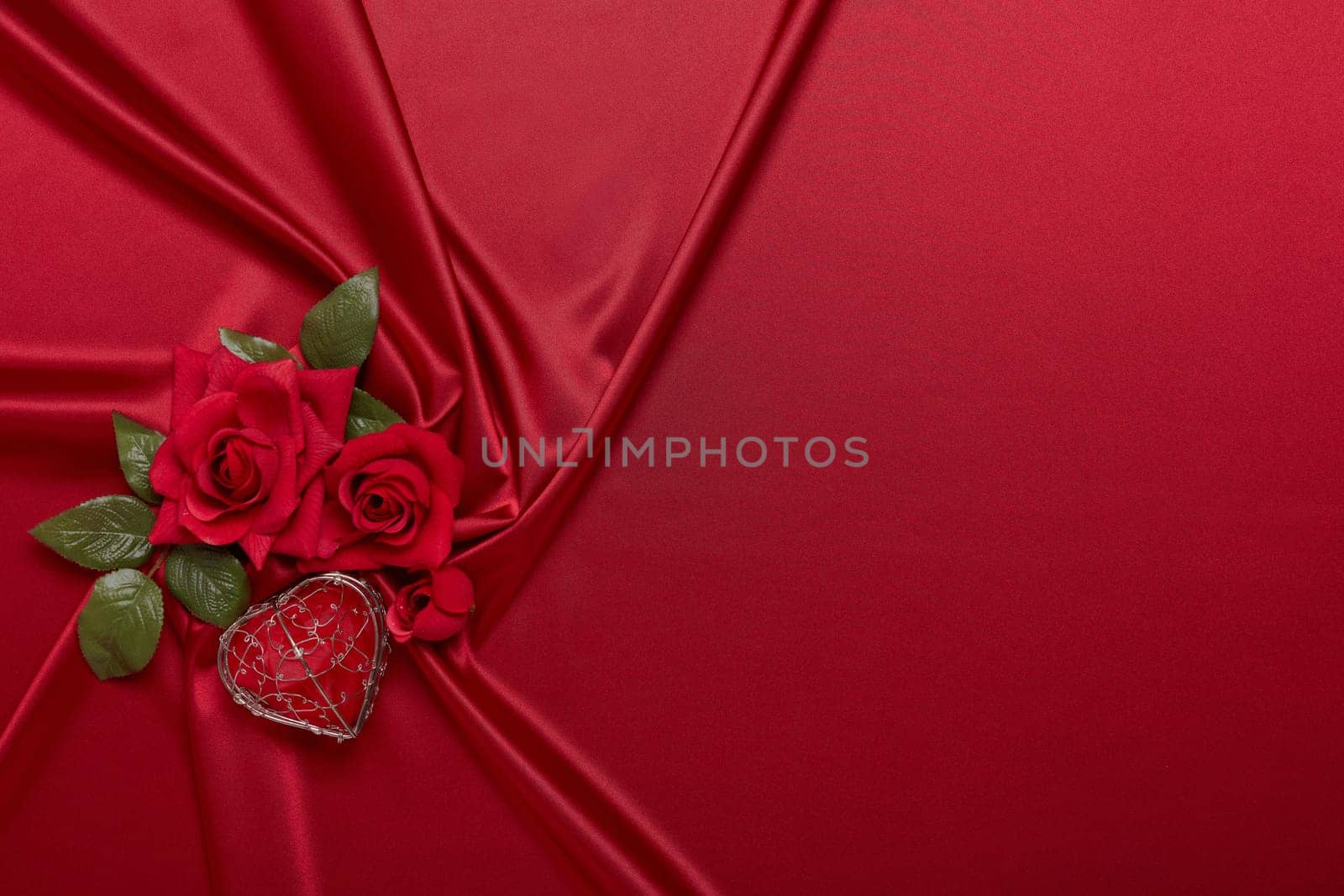 Abstract background from red silk (satin), roses and heart. Fabric texture with draped. Top view with copy space. Element design. Valentine's day. Wedding day.  Women' s day. Greeting card