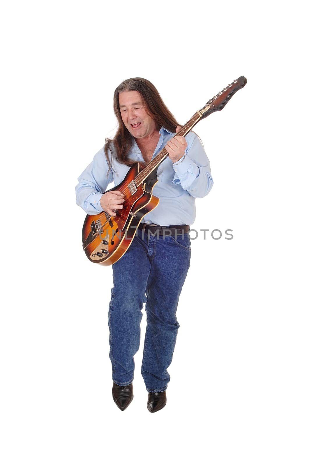 A happy musician playing his guitar with his long brunette.hair, singing, isolated for white background.
