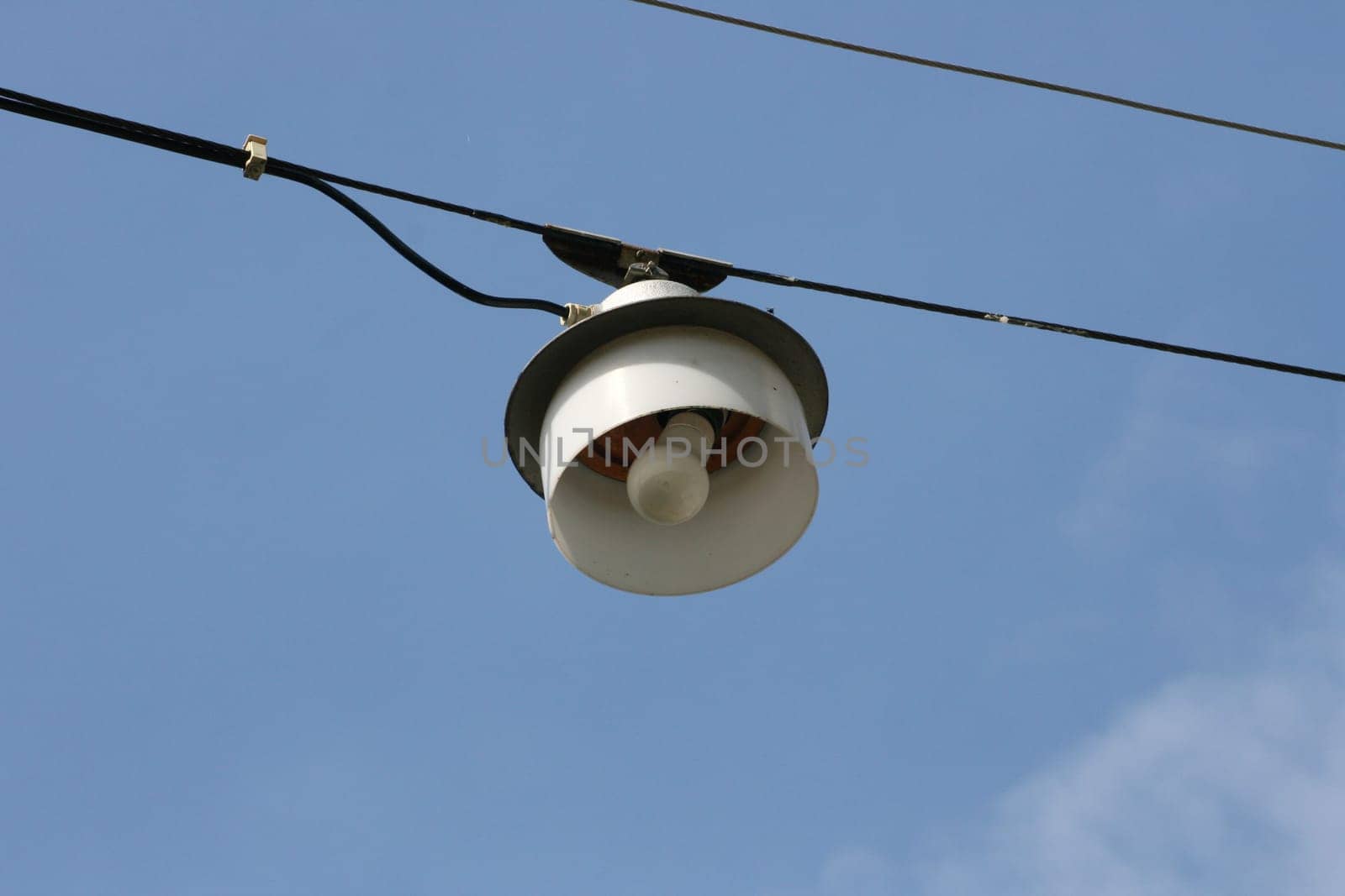 Street lamp on a steel cable suspended above the road