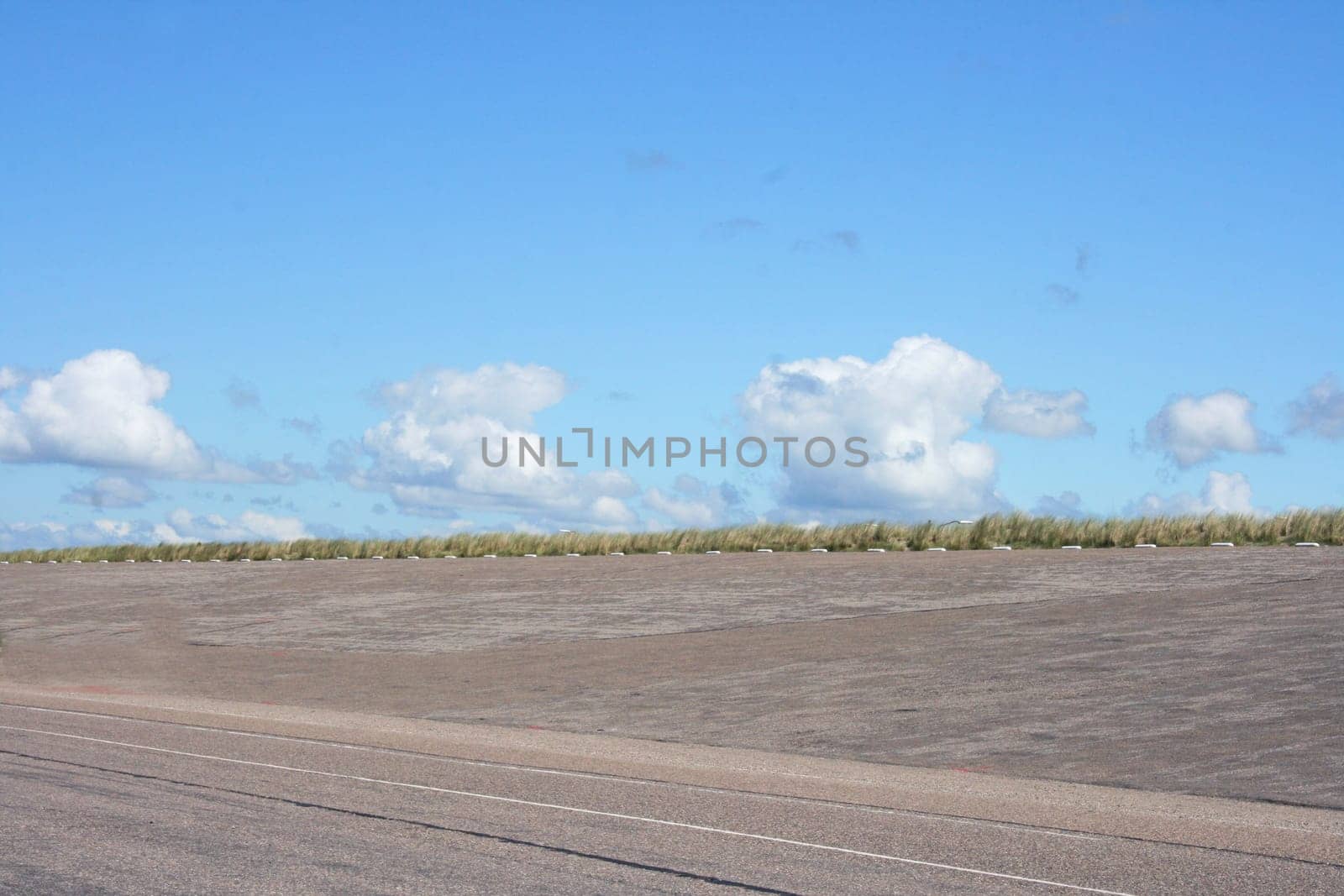 Dam at the Dutch North Sea coast, with blue sky in background