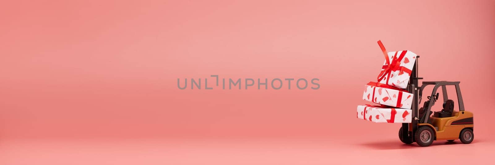 Forklift and gift boxes on pink background with copy space. Valentine's Day. Wedding Day