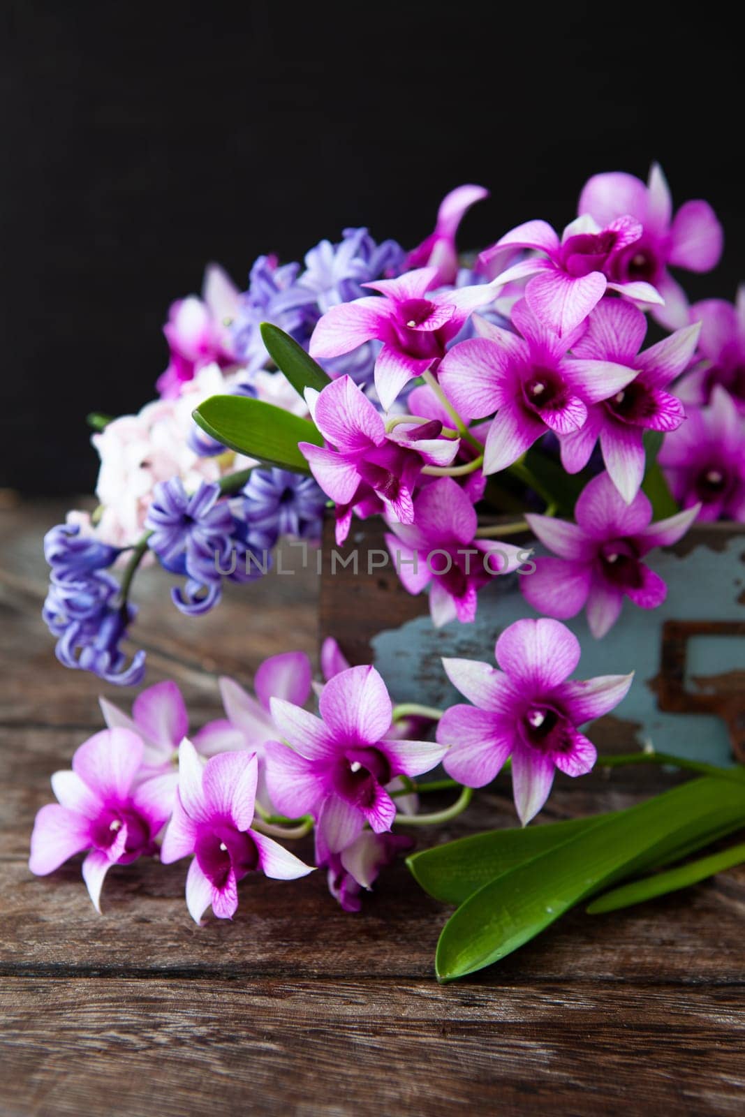 Fresh orchids and hyacinths in vintage wooden crate