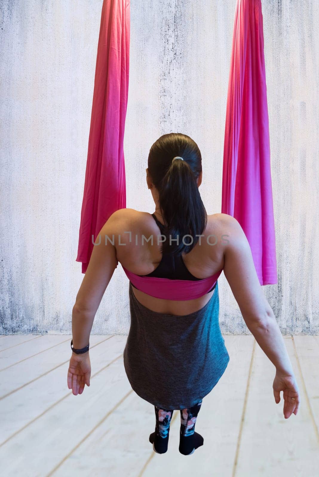 Young woman making antigravity yoga exercises in hammock